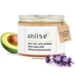 Nourishing body cream infused with wild yam and antioxidants for deep hydration and healthy, radiant skin. Displayed on table with a halved avocado and a lavender stem in front of white background.