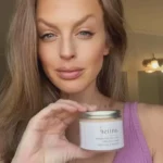 Nourishing body cream infused with wild yam and antioxidants for deep hydration and healthy, radiant skin. Lady holding container in front of her for display,