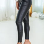 Side view of Heidi Faux Leather Zipper Detailed Leggings featuring a sleek high-waisted fit, shiny faux leather finish, and chic front zipper accents — perfect for edgy street style or night-out looks.