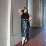Model wearing a chic faux leather maxi wrap skirt with a high waist and side tie detail, showcasing a sleek, elegant look perfect for modern street style or evening wear.