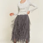 Model wearing stylish layered polka dot mesh lined midi skirt for women, flowy and elegant, perfect for casual or party wear.