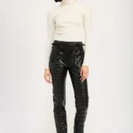 Model wearing edgy lace-up leather trousers with high-waist design and front lace-up detailing, styled for a sleek, modern, and fashion-forward look.