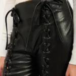 Close-up of lace-up leather trousers highlighting the front lace-up detail, smooth leather texture, and high-waist stitching for a chic, edgy finish.