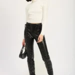 Model wearing edgy lace-up leather trousers with high-waist design and front lace-up detailing, styled for a sleek, modern, and fashion-forward look.