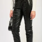Close up of stylish lace-up leather trousers for women featuring corset-style front lacing and ankle-length cut