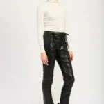 Side view of women’s lace-up leather trousers showing sleek fit and smooth shine