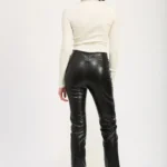 Back view of lace-up leather trousers showing the fitted silhouette, high-waist design, and sleek leather texture for a stylish and edgy look.