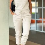 Front view of crew neck short sleeve jumpsuit with drawstring waist, lightweight summer one-piece outfit for women.