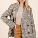 Model layering plaid double-breasted blazer over a casual outfit for chic style