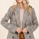 Model layering plaid double-breasted blazer over a casual outfit for chic style