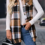 Model layering straw yellow button-up vest over turtleneck sweater