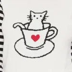 Close-up of cat in cup jacquard design on sweater top for women