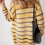Model showing back of striped pom pom knit cardigan paired with jeans for casual fall look