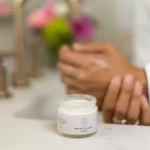 Woman applying lavender shea butter body cream to hands for smooth hydrated skin