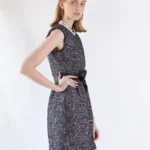 Side view of ebony mini tweed dress showing fitted silhouette and elegant black tweed texture
