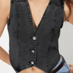 Detailed view of cropped denim vest on model highlighting front buttons and tailored cropped silhouette